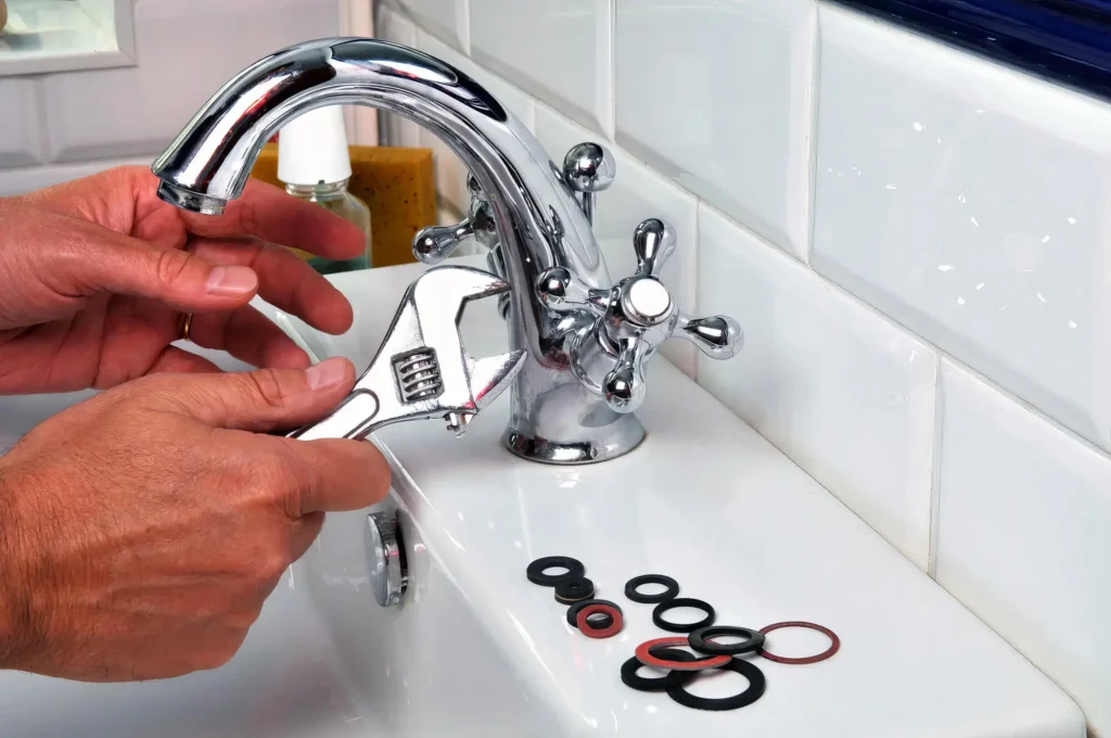Plumber performing maintenance on a bathroom faucet in Greeley