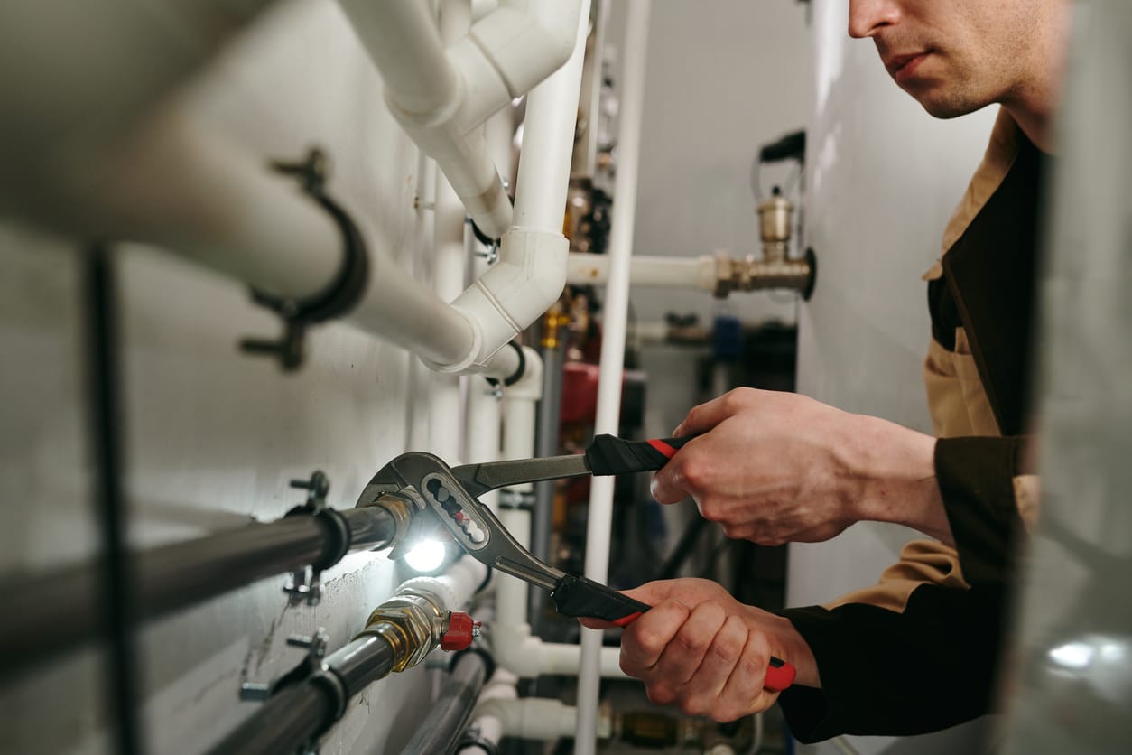 Plumbers maintaining commercial plumbing pipes in Greeley