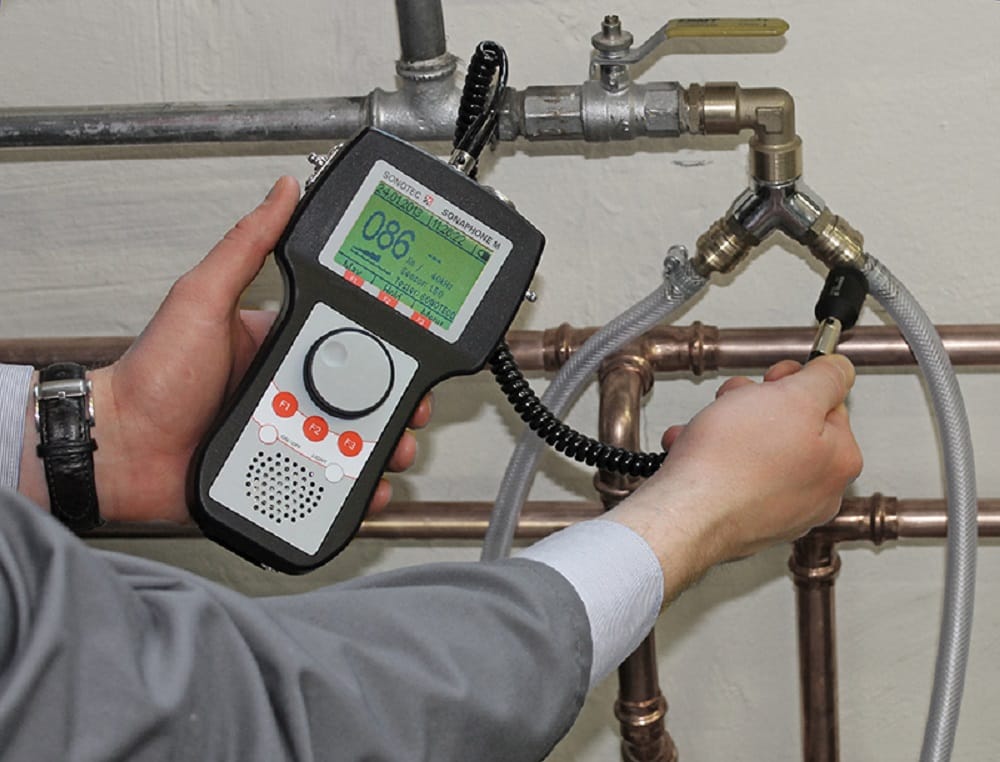 Plumber testing pipes with electronic leak detection equipment in Greeley