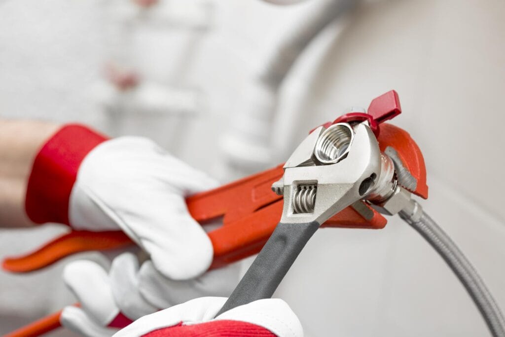 Plumber holding pipe wrenches for an emergency repair in Greeley