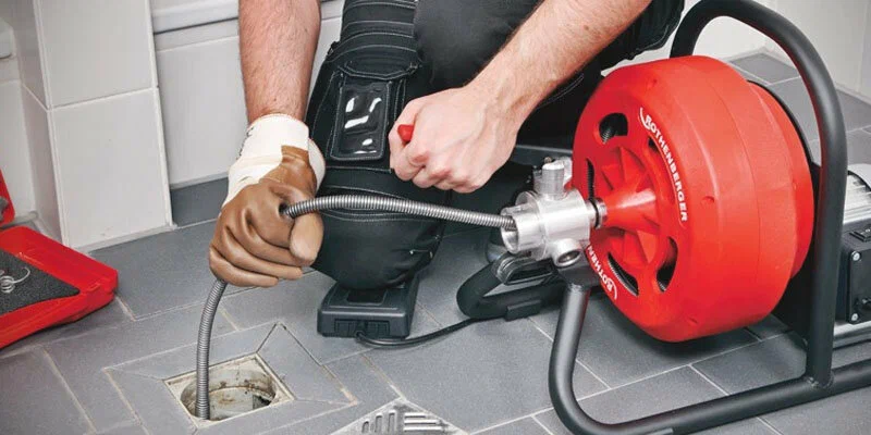 Plumber using a drain-cleaning machine in Greeley