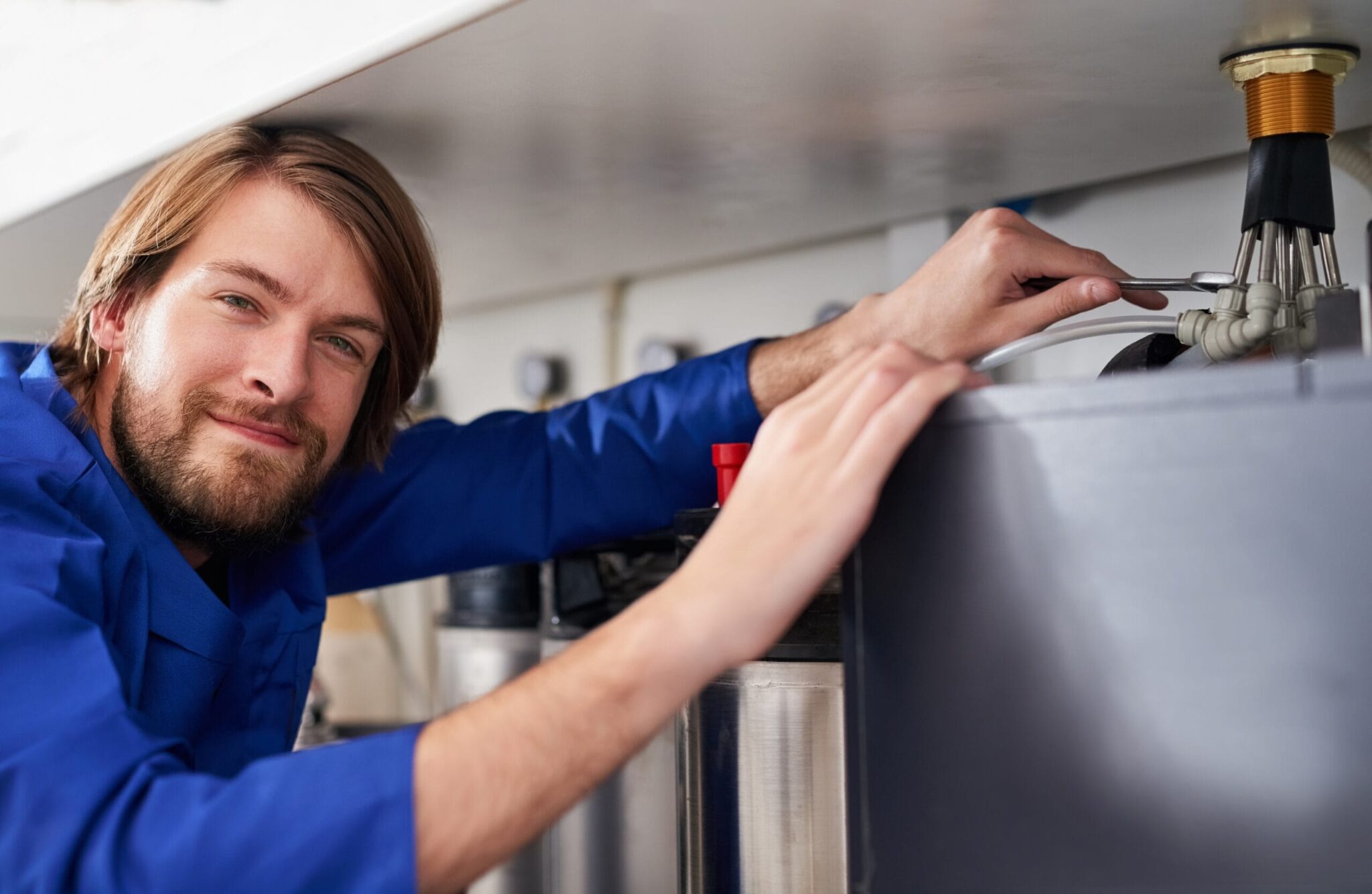 Technician servicing a residential water heater tank in Greeley